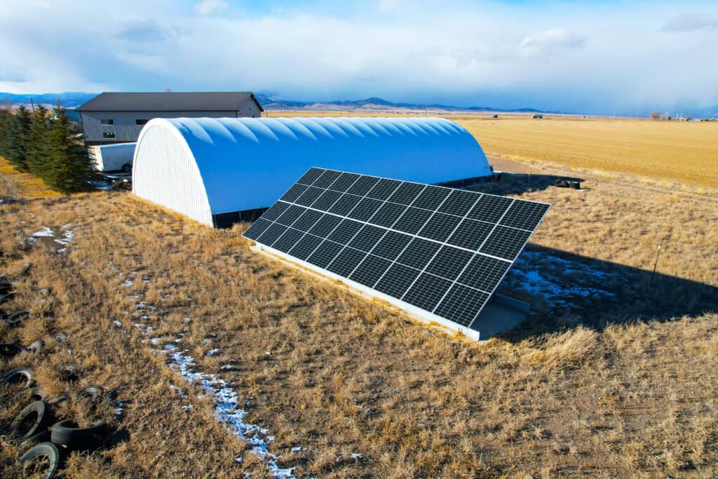 Ground-mount solar system providing backup power beside a farm building